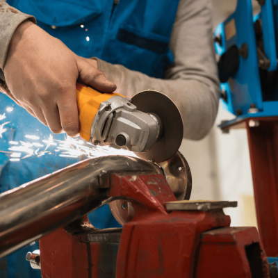 Technician Cutting Metal WithMany Sharp Sparks Equipm